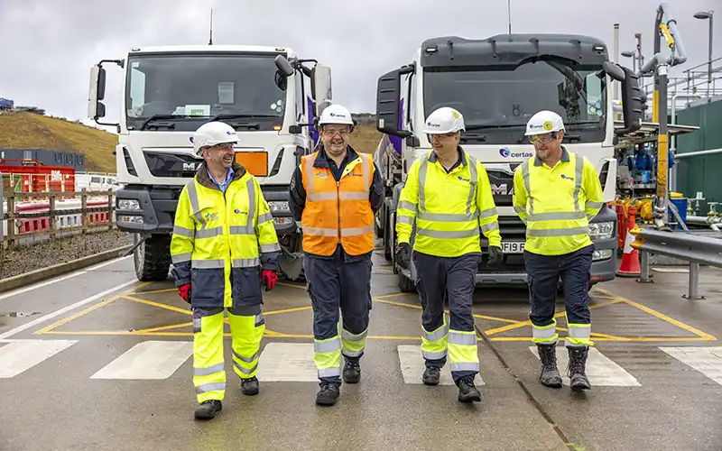 4 Certas Energy drivers stood in front of two oil trucks.